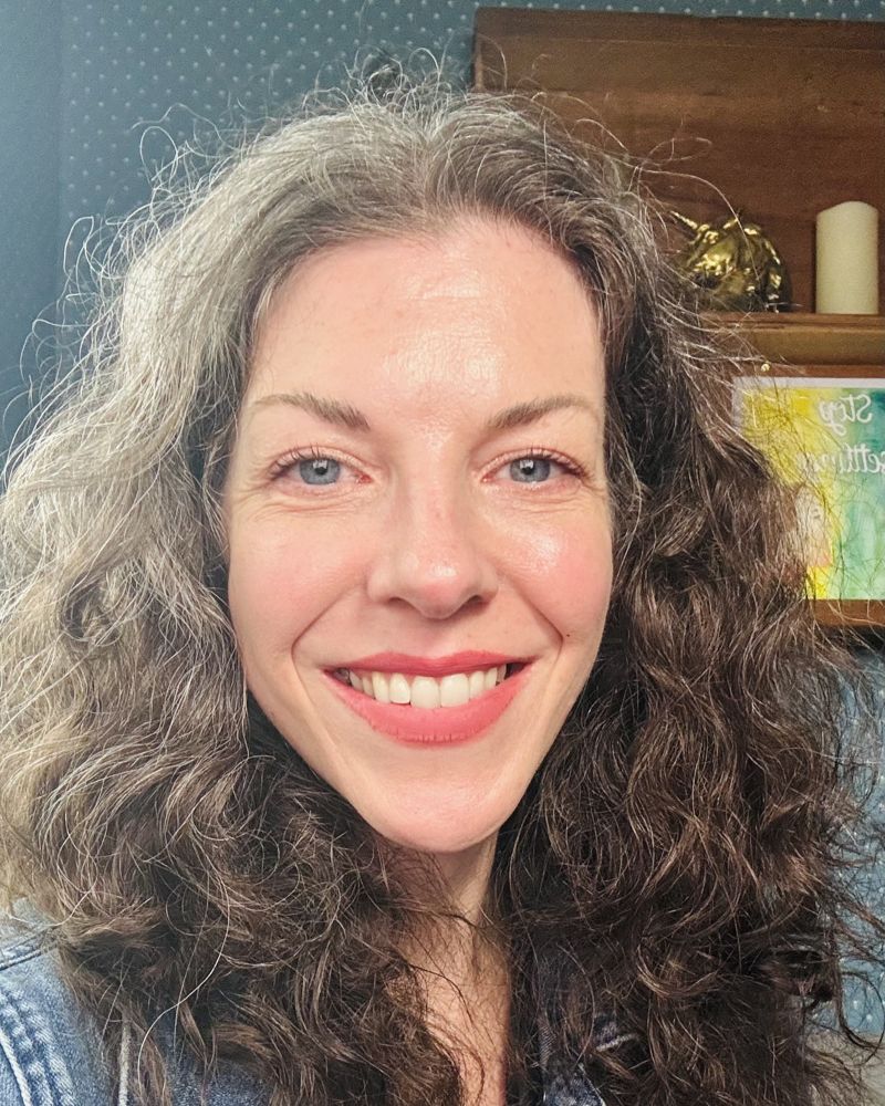 Evelyn smiling at home in a denim jacket